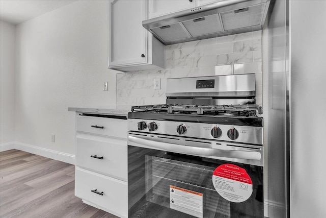 kitchen featuring stainless steel gas stove, tasteful backsplash, range hood, light hardwood / wood-style floors, and white cabinets