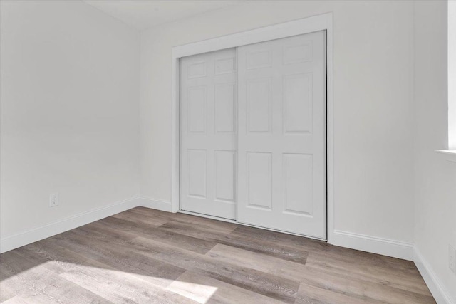 unfurnished bedroom featuring a closet and light hardwood / wood-style flooring