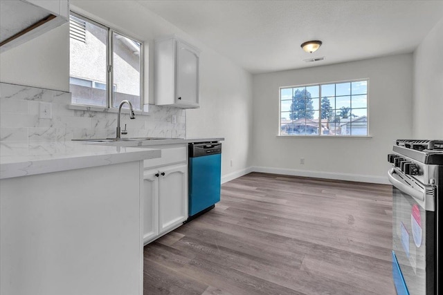 kitchen with white cabinetry, black dishwasher, sink, backsplash, and stainless steel gas range