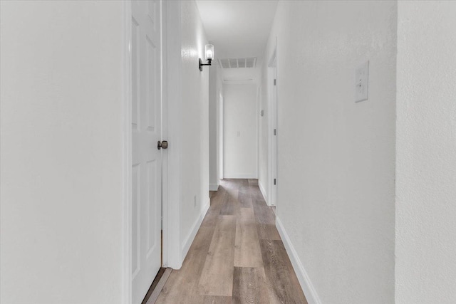 corridor with light hardwood / wood-style floors