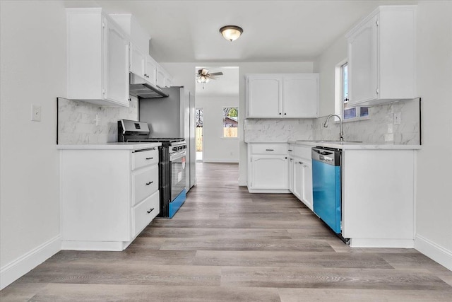 kitchen featuring appliances with stainless steel finishes, white cabinets, ceiling fan, and light hardwood / wood-style flooring