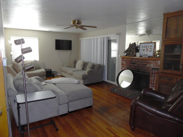 living room with a wealth of natural light, dark wood-type flooring, and ceiling fan