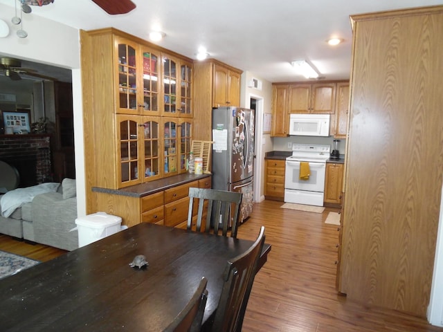 dining area featuring hardwood / wood-style flooring, a fireplace, and ceiling fan