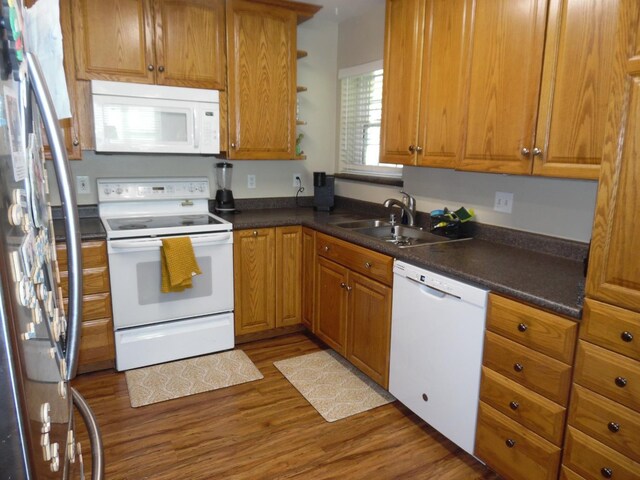 kitchen with hardwood / wood-style flooring, white appliances, and sink