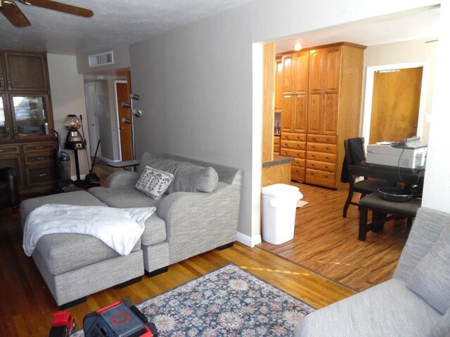 living room with dark wood-type flooring and ceiling fan