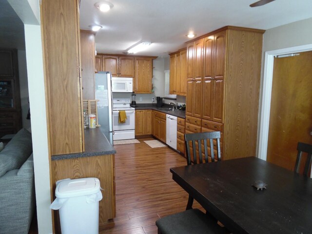 kitchen featuring white appliances, dark hardwood / wood-style flooring, and sink