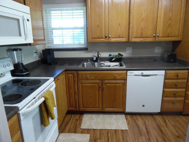 kitchen featuring white appliances, dark hardwood / wood-style floors, and sink