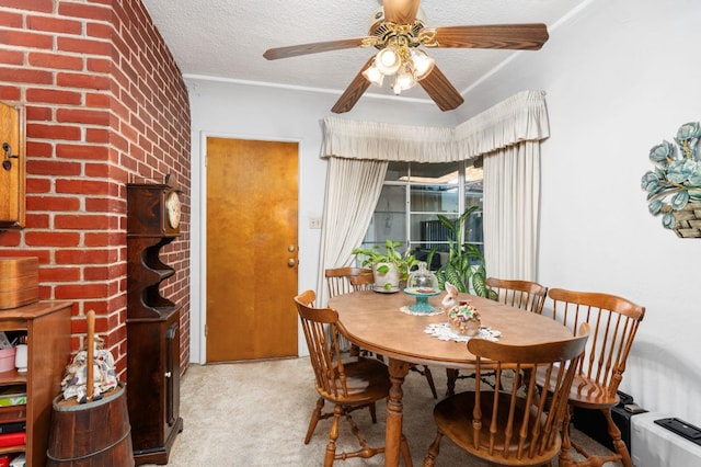 carpeted dining area with ceiling fan and a textured ceiling