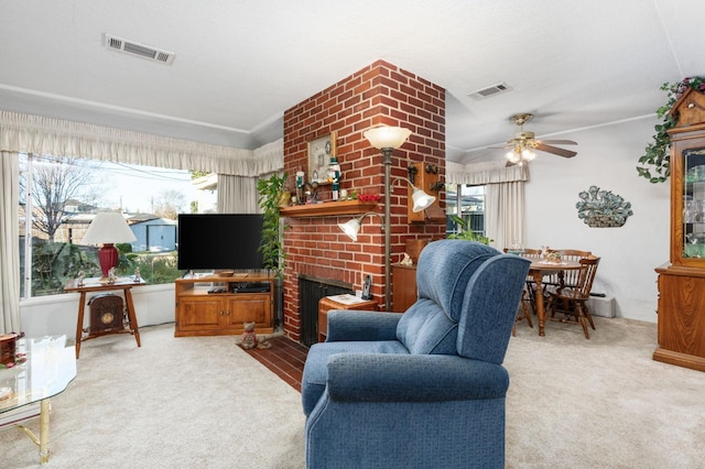 living room featuring a brick fireplace, carpet floors, a healthy amount of sunlight, and ceiling fan