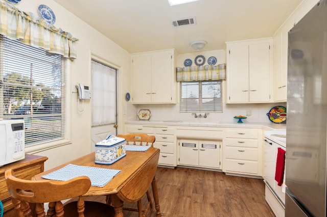 kitchen featuring stainless steel refrigerator, white cabinetry, sink, backsplash, and dark hardwood / wood-style flooring