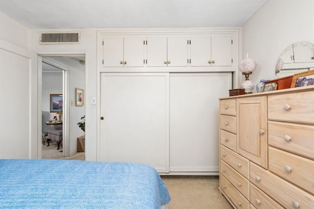 bedroom with light carpet and a closet