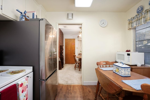 kitchen with dark hardwood / wood-style floors, stainless steel fridge, white cabinets, ceiling fan, and stove