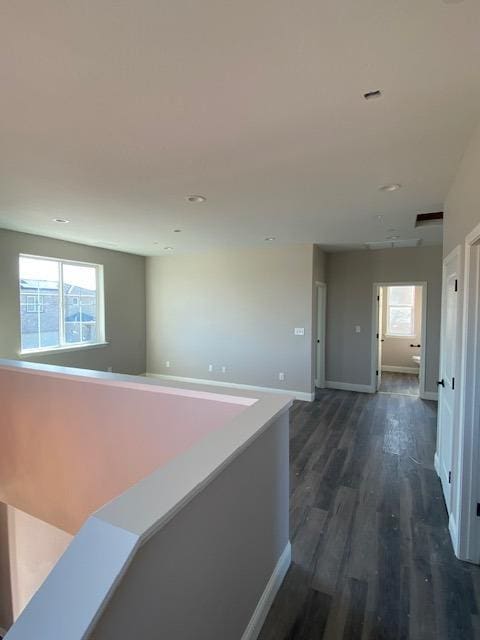 corridor with plenty of natural light and dark hardwood / wood-style flooring