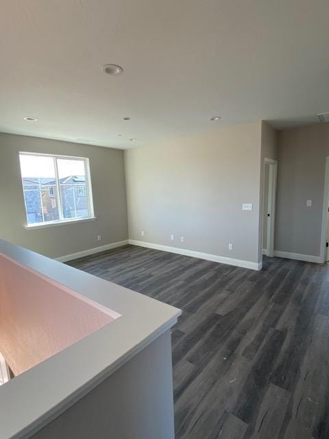 unfurnished room with dark hardwood / wood-style flooring