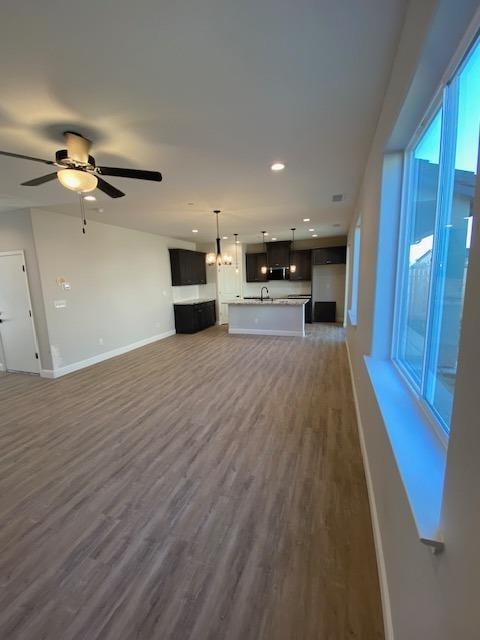 unfurnished living room featuring sink, dark hardwood / wood-style floors, and ceiling fan