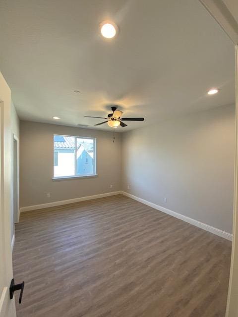 spare room featuring dark hardwood / wood-style flooring and ceiling fan