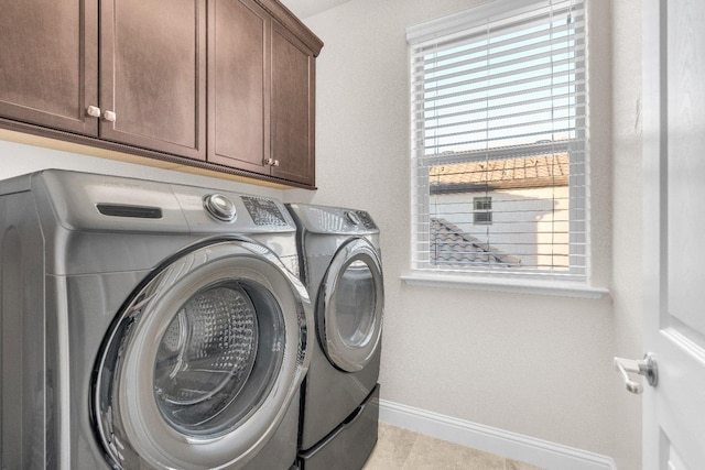 laundry room featuring cabinets, separate washer and dryer, a healthy amount of sunlight, and light tile patterned floors