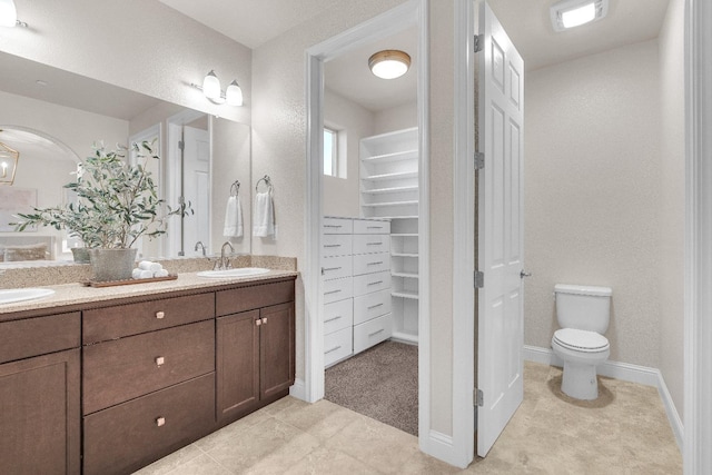 bathroom featuring vanity, tile patterned flooring, and toilet