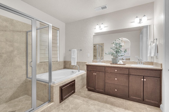 bathroom featuring plus walk in shower, vanity, and tile patterned floors