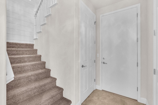 stairway featuring carpet flooring