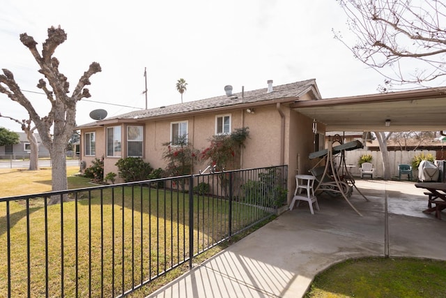 exterior space featuring a patio, a front yard, fence, and stucco siding