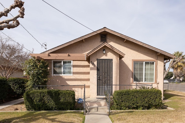 bungalow-style house with stucco siding