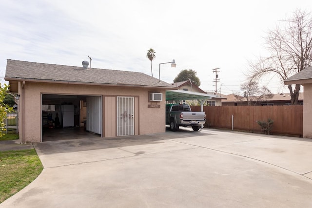 garage with a detached garage and fence