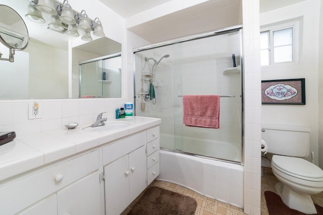 full bath featuring toilet, enclosed tub / shower combo, and vanity