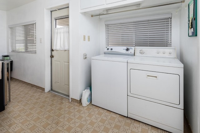 laundry room featuring light floors, independent washer and dryer, and cabinet space