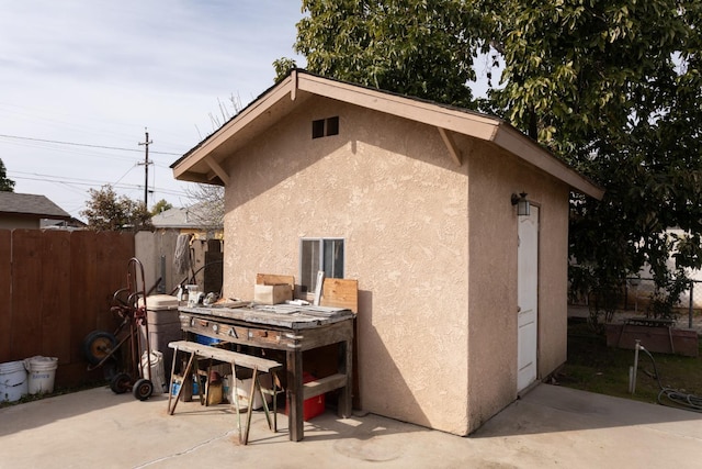 view of side of home with a patio, fence, and stucco siding