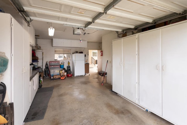 garage with a garage door opener and freestanding refrigerator