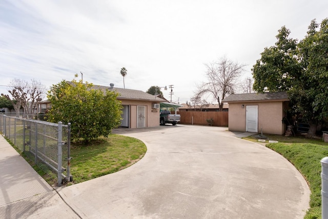 view of front of property featuring a front yard, fence, concrete driveway, and stucco siding