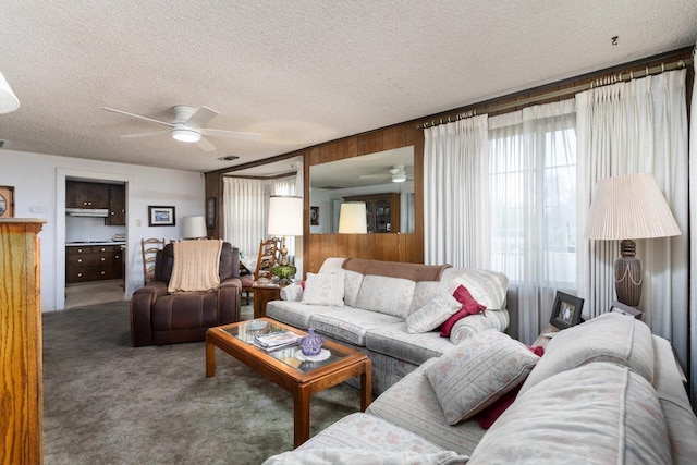 carpeted living room with a textured ceiling and a ceiling fan