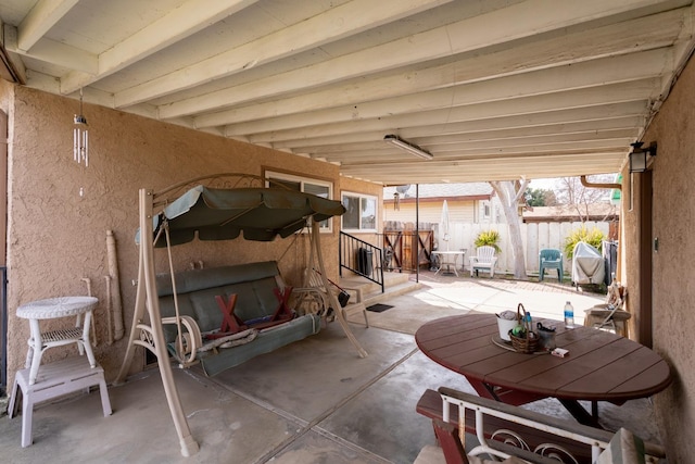 view of patio featuring outdoor dining space and fence