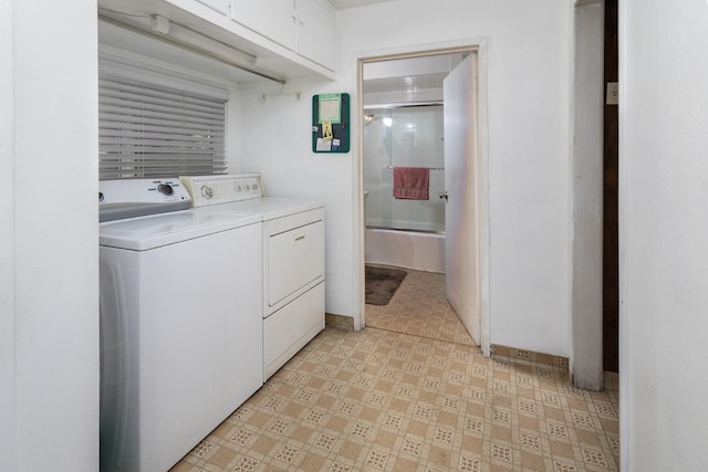 laundry area with light floors, washing machine and dryer, and cabinet space