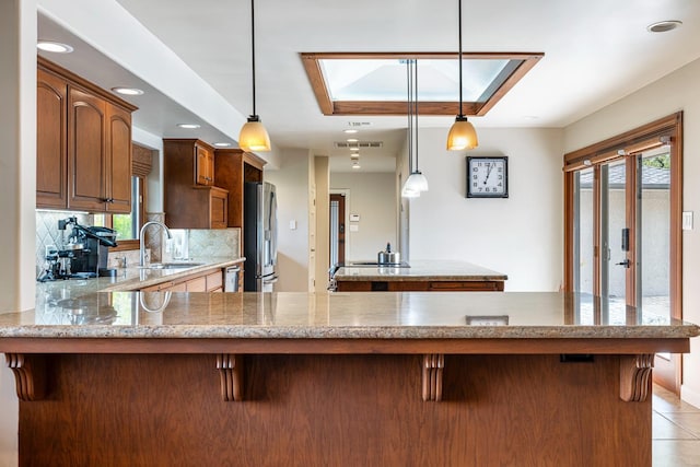 kitchen with pendant lighting, appliances with stainless steel finishes, sink, and tasteful backsplash