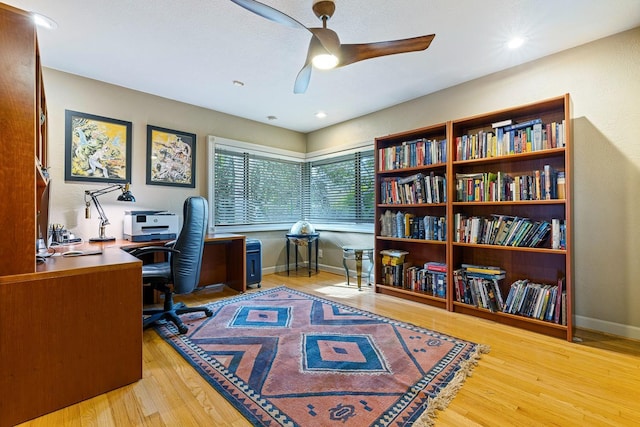 office with light hardwood / wood-style flooring and ceiling fan