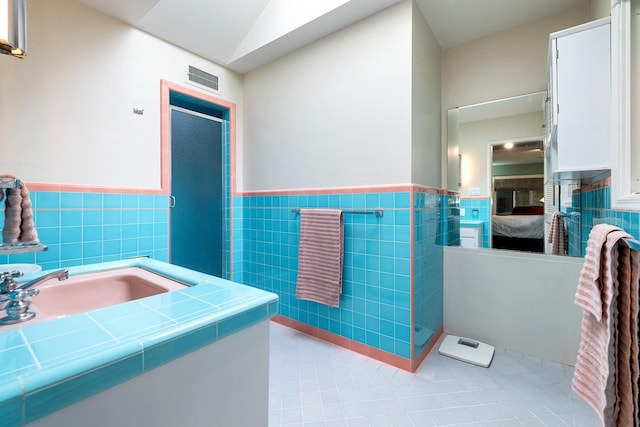 bathroom with tile walls and tile patterned floors