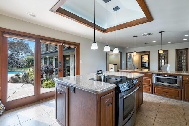 kitchen with stainless steel electric range oven, pendant lighting, a raised ceiling, light stone countertops, and a center island with sink