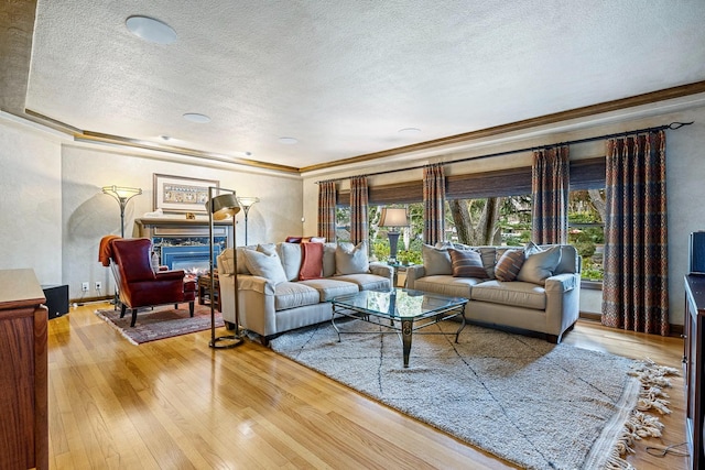 living room with hardwood / wood-style flooring, a high end fireplace, and a textured ceiling