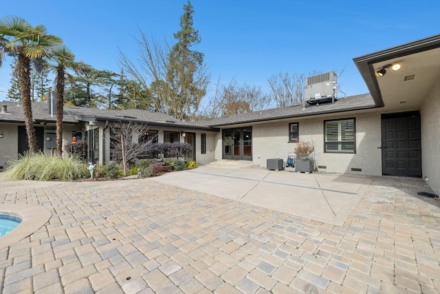 rear view of house with central AC unit and a patio area