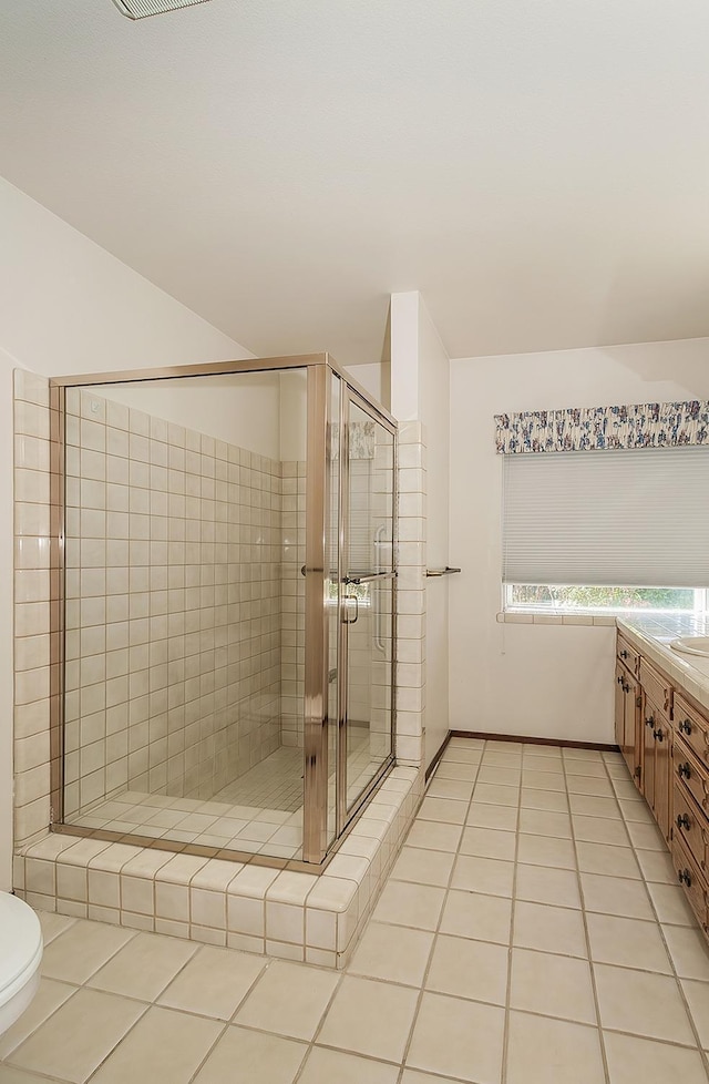 bathroom with tile patterned flooring, vanity, lofted ceiling, and an enclosed shower