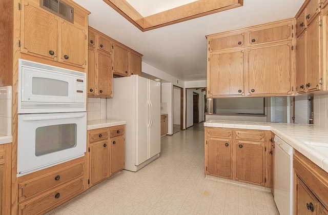 kitchen featuring white appliances and tile counters