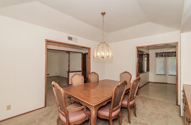 carpeted dining area with lofted ceiling, a tray ceiling, and a notable chandelier