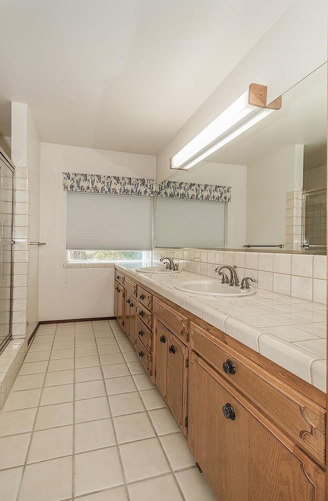 bathroom featuring tile patterned flooring, vanity, and tasteful backsplash