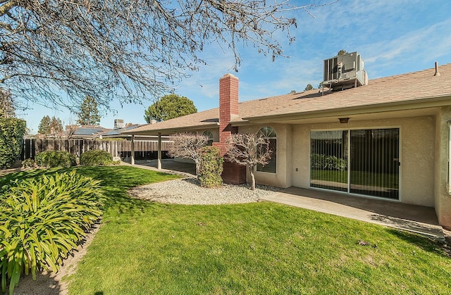 rear view of house featuring a patio area, central air condition unit, and a lawn