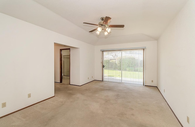 empty room featuring light carpet, vaulted ceiling, and ceiling fan