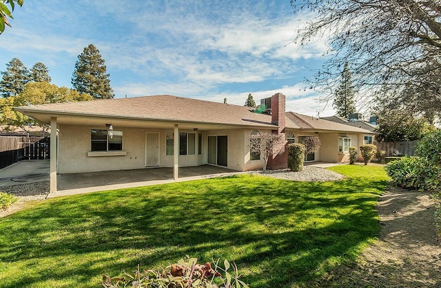 back of property featuring a lawn and a patio