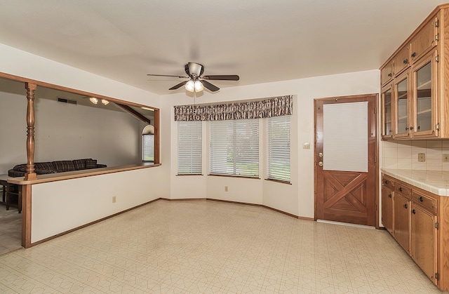 interior space featuring tasteful backsplash, tile countertops, and ceiling fan