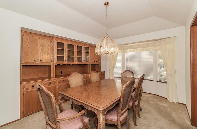 carpeted dining space featuring a chandelier